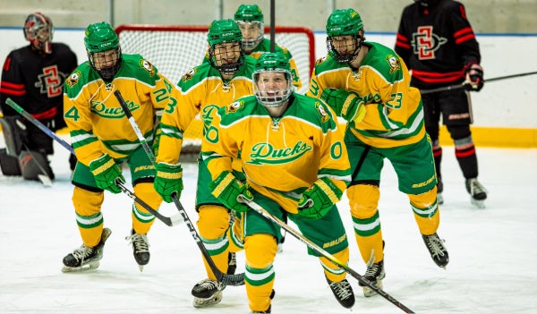 Hockey team smiling during a match.